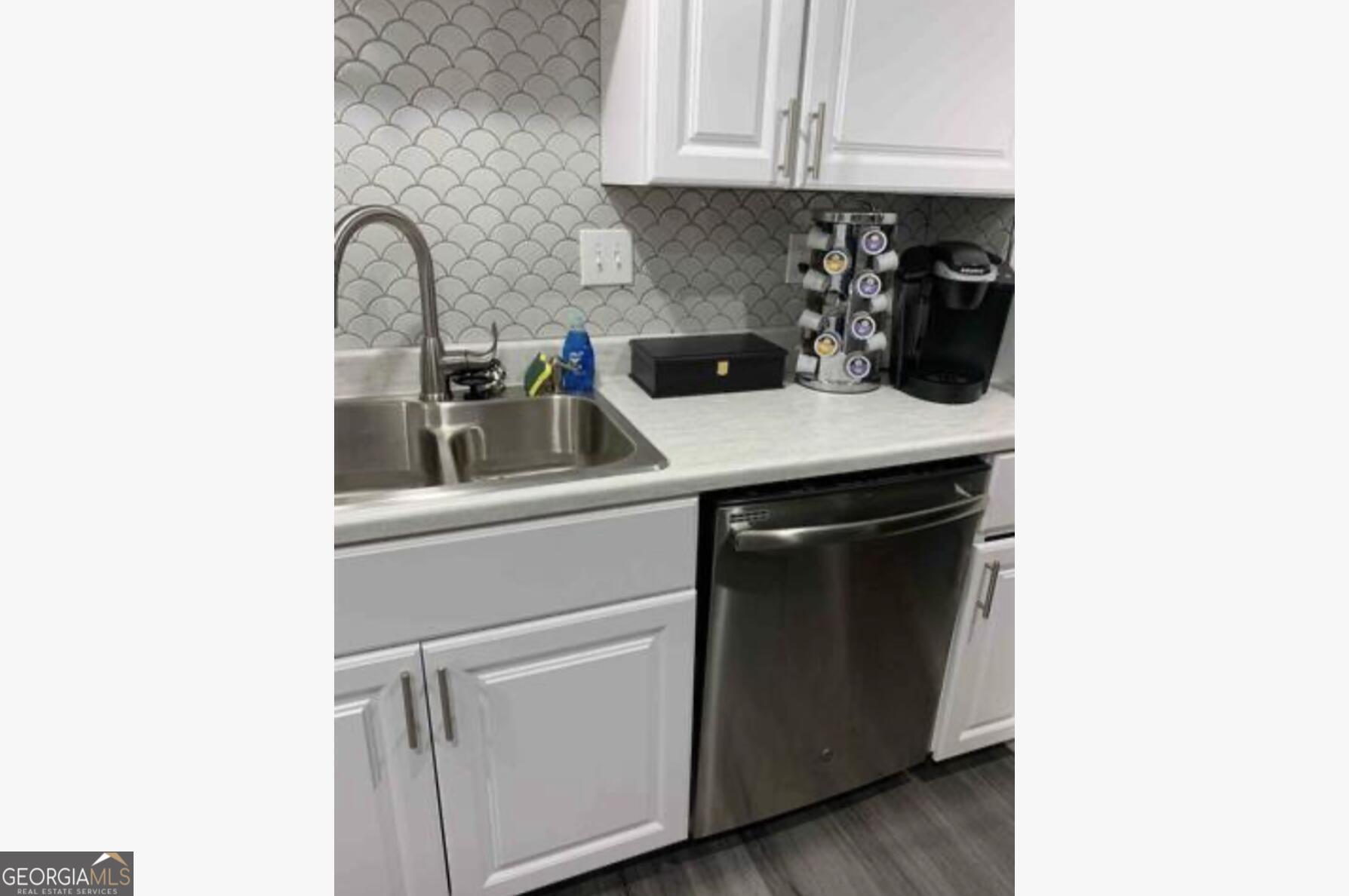 3834 Kensingwood Trace Decatur, GA 30032 - Photo 24 of 26 a kitchen with stainless steel appliances granite countertop a sink and a white cabinets
