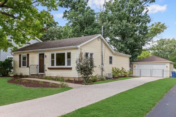 a front view of a house with a garden and yard