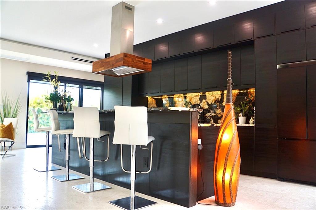 1391 Oakes Boulevard Naples, FL 34119 - Photo 26 of 43 Kitchen with a kitchen breakfast bar, built in refrigerator, island range hood, and backsplash