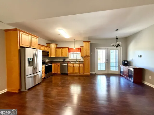 a kitchen with stainless steel appliances wooden floor and a refrigerator