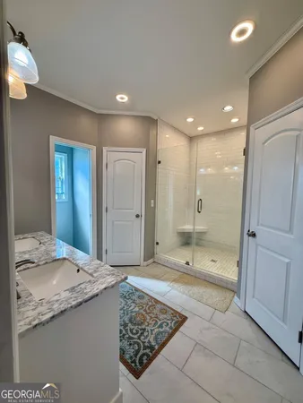 a bathroom with a granite countertop sink a toilet and shower