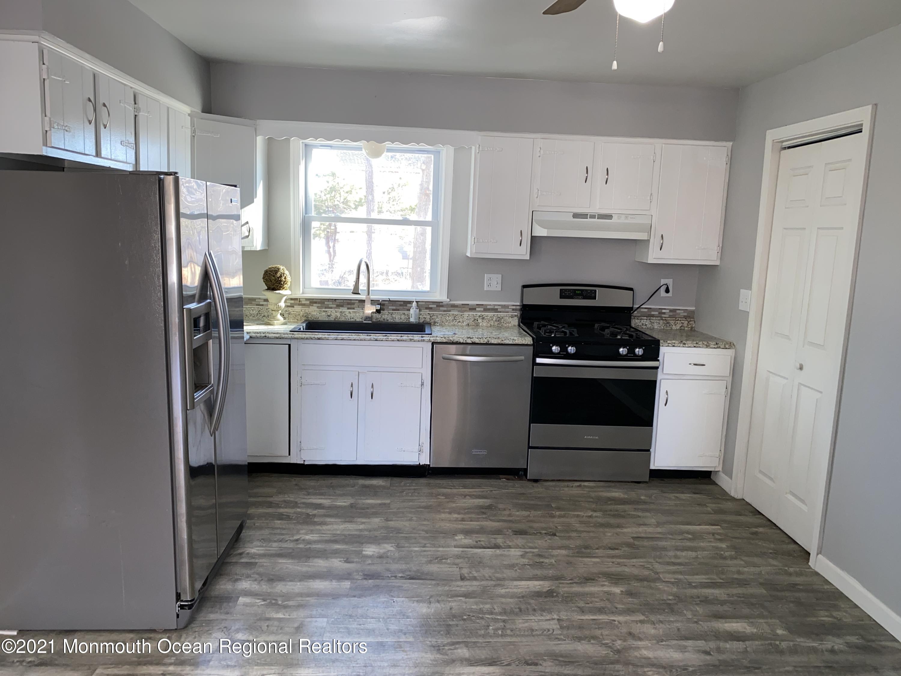 295 Western Boulevard Bayville, NJ 08721 - Photo 5 of 11 a kitchen with granite countertop a refrigerator a sink a stove and cabinets