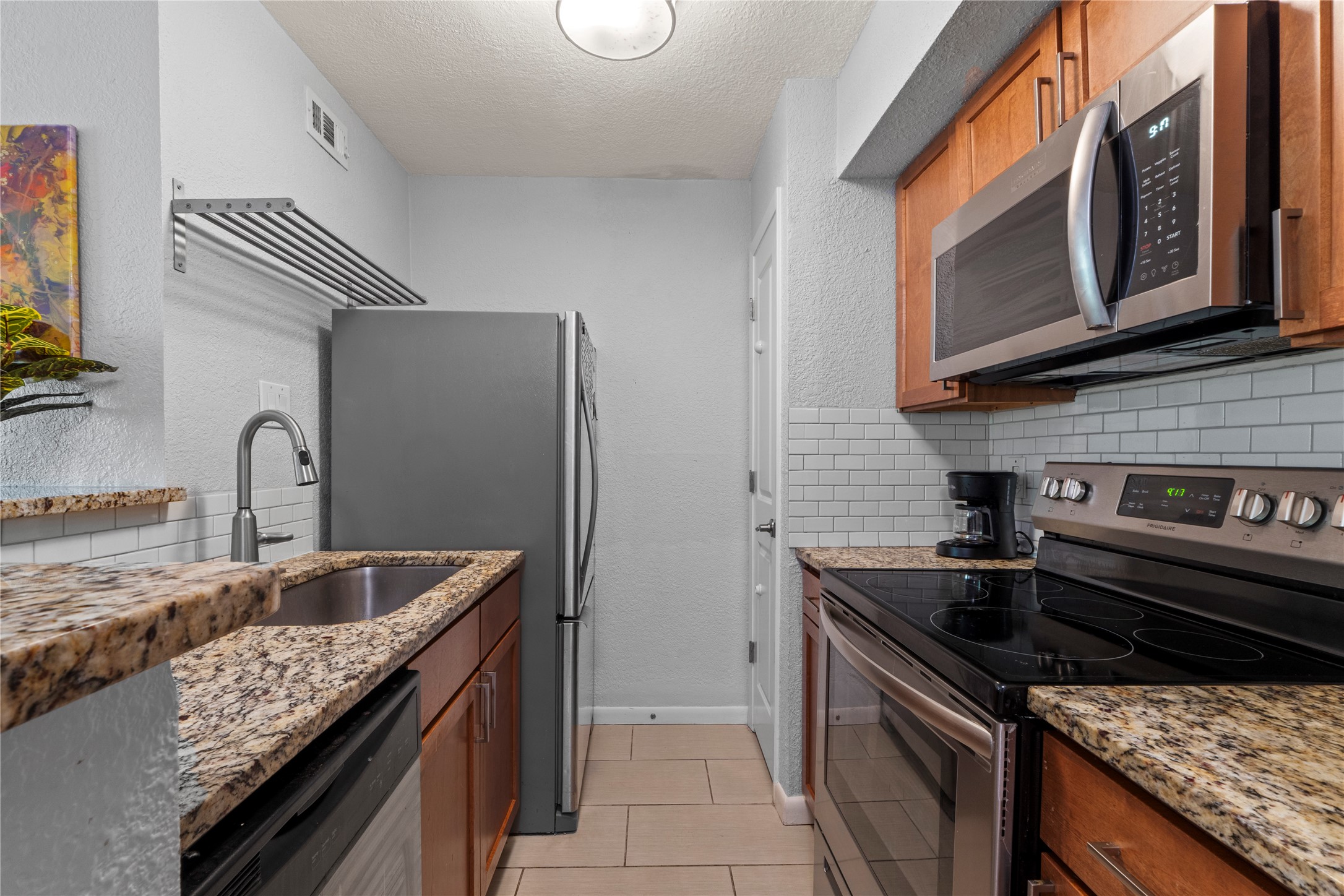 3204 Menchaca Road, Unit 305 Austin, TX 78704 - Photo 13 of 25 Smooth electric top cooking range, full-size dishwasher, microwave, and refrigerator.