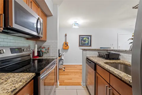 a kitchen with stainless steel appliances granite countertop a sink stove and refrigerator