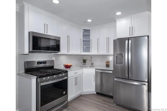 a kitchen with a refrigerator stove and white cabinets