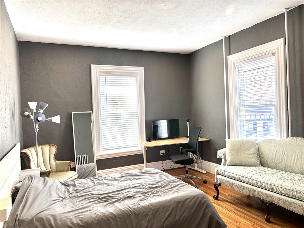 170 Poplar Street, Unit 1 Boston, MA 02131 - Photo 13 of 20 a bedroom with a bed and a couch