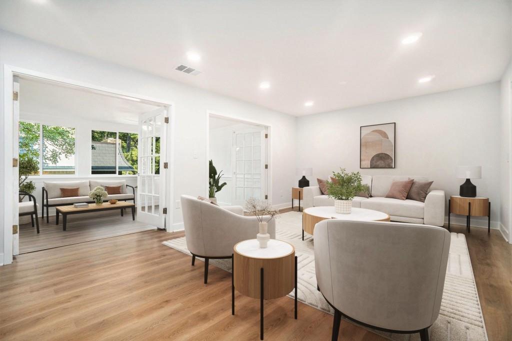a living room with furniture a wooden floor and a large window