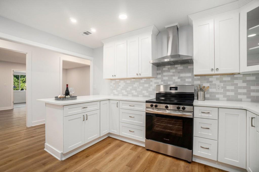 46 La Rue Place Northwest Atlanta, GA 30327 - Photo 12 of 28 a kitchen with white cabinets stainless steel appliances and wooden floor