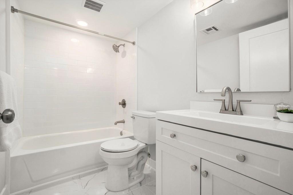 46 La Rue Place Northwest Atlanta, GA 30327 - Photo 19 of 28 a bathroom with a sink a toilet and a mirror