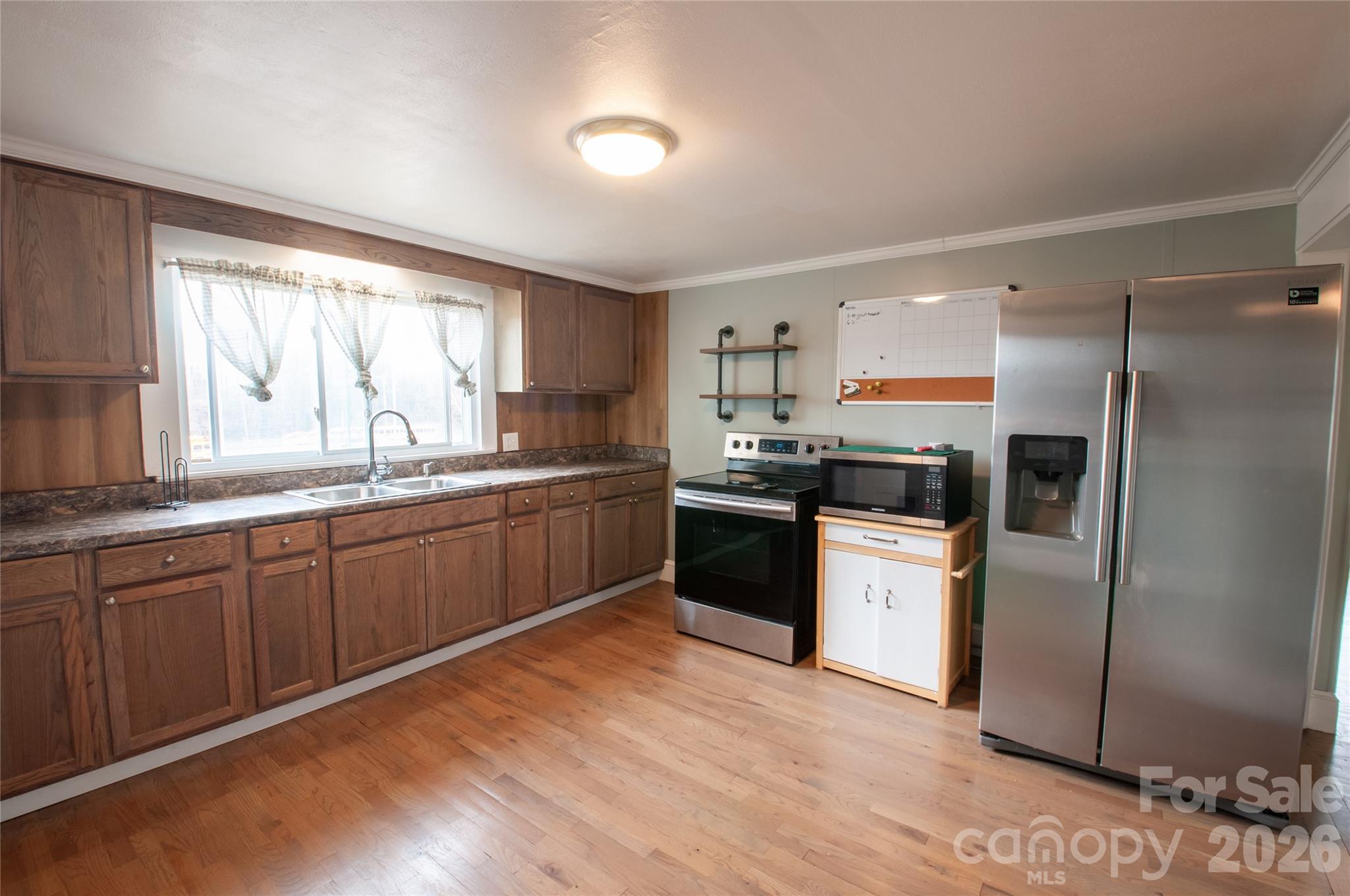 127 Bristol Road Statesville, NC 28677 - Photo 4 of 10 a kitchen with a sink a window a refrigerator and stainless steel appliances
