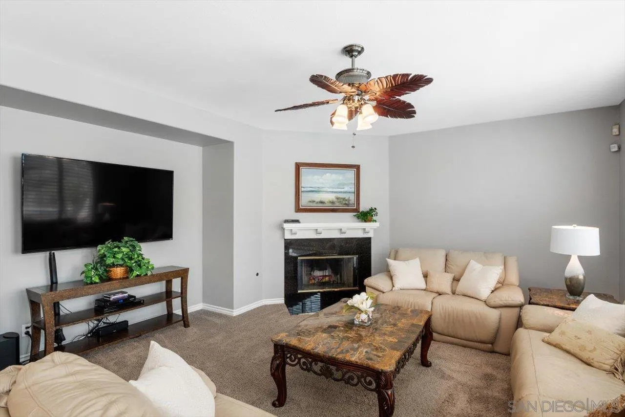 565 Hidden Trails Road Escondido, CA 92027 - Photo 20 of 52 a living room with furniture a flat screen tv and a fireplace