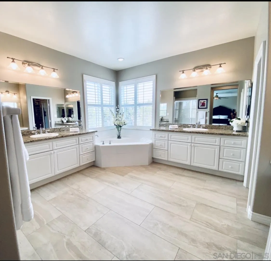565 Hidden Trails Road Escondido, CA 92027 - Photo 31 of 52 a large white kitchen with a sink and dishwasher with a fireplace