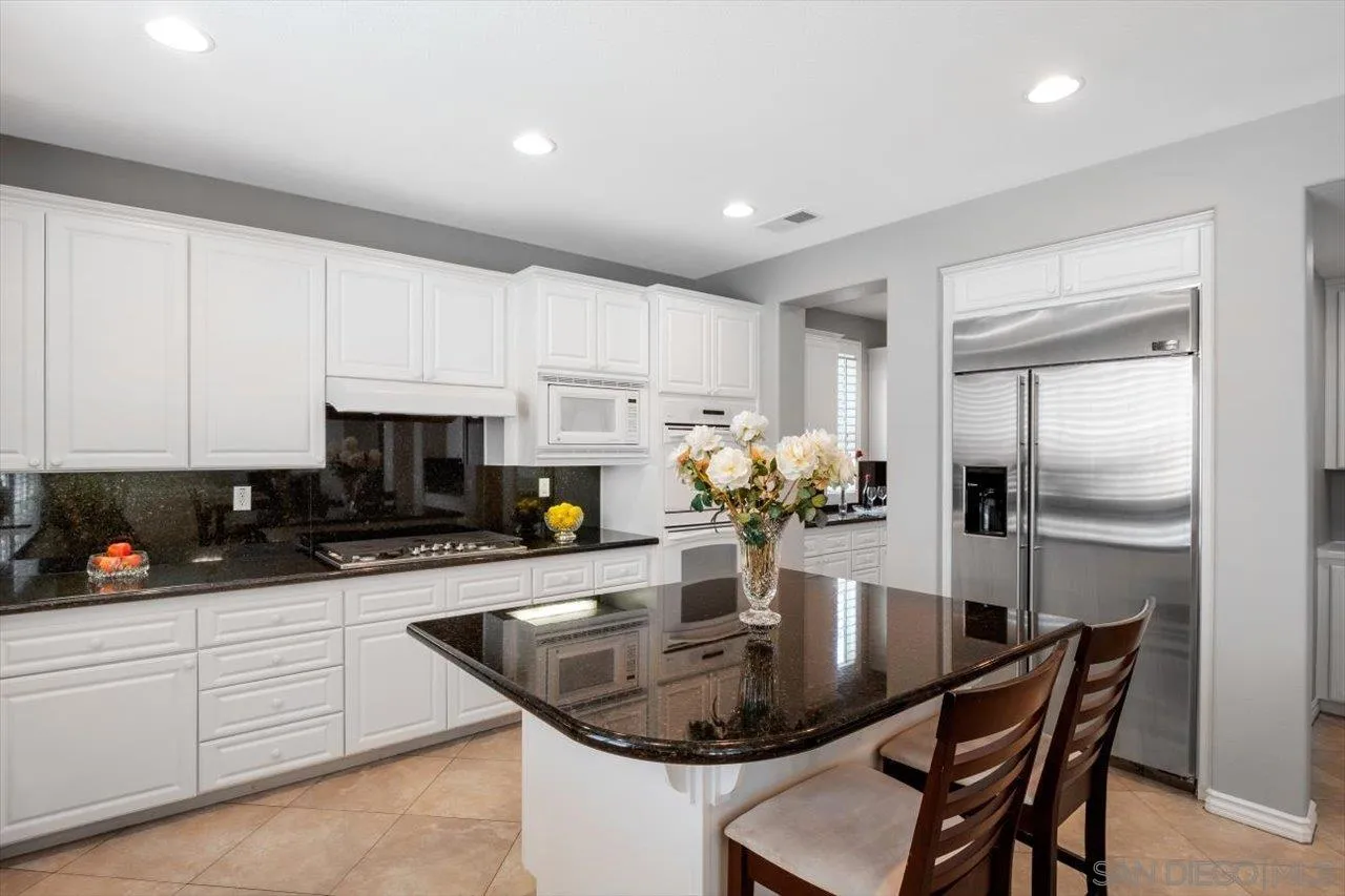 565 Hidden Trails Road Escondido, CA 92027 - Photo 7 of 52 a kitchen with granite countertop a sink stove and refrigerator