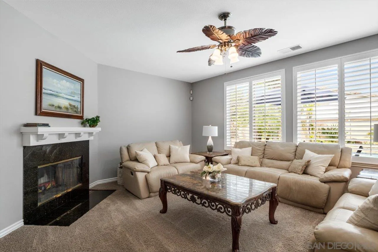 565 Hidden Trails Road Escondido, CA 92027 - Photo 8 of 52 a living room with furniture a chandelier and a fireplace