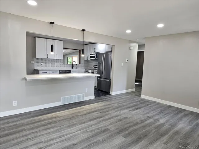 a view of a kitchen with wooden floor and a window