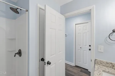 a bathroom with a granite countertop sink a toilet and mirror