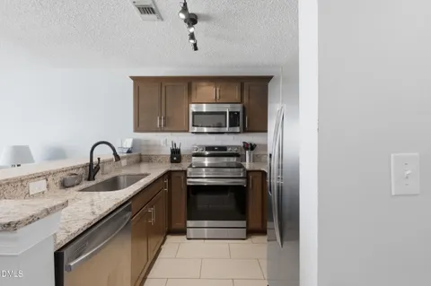 a kitchen with stainless steel appliances granite countertop a sink stove and microwave