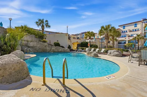 an aerial view of a swimming pool with yard and outdoor seating