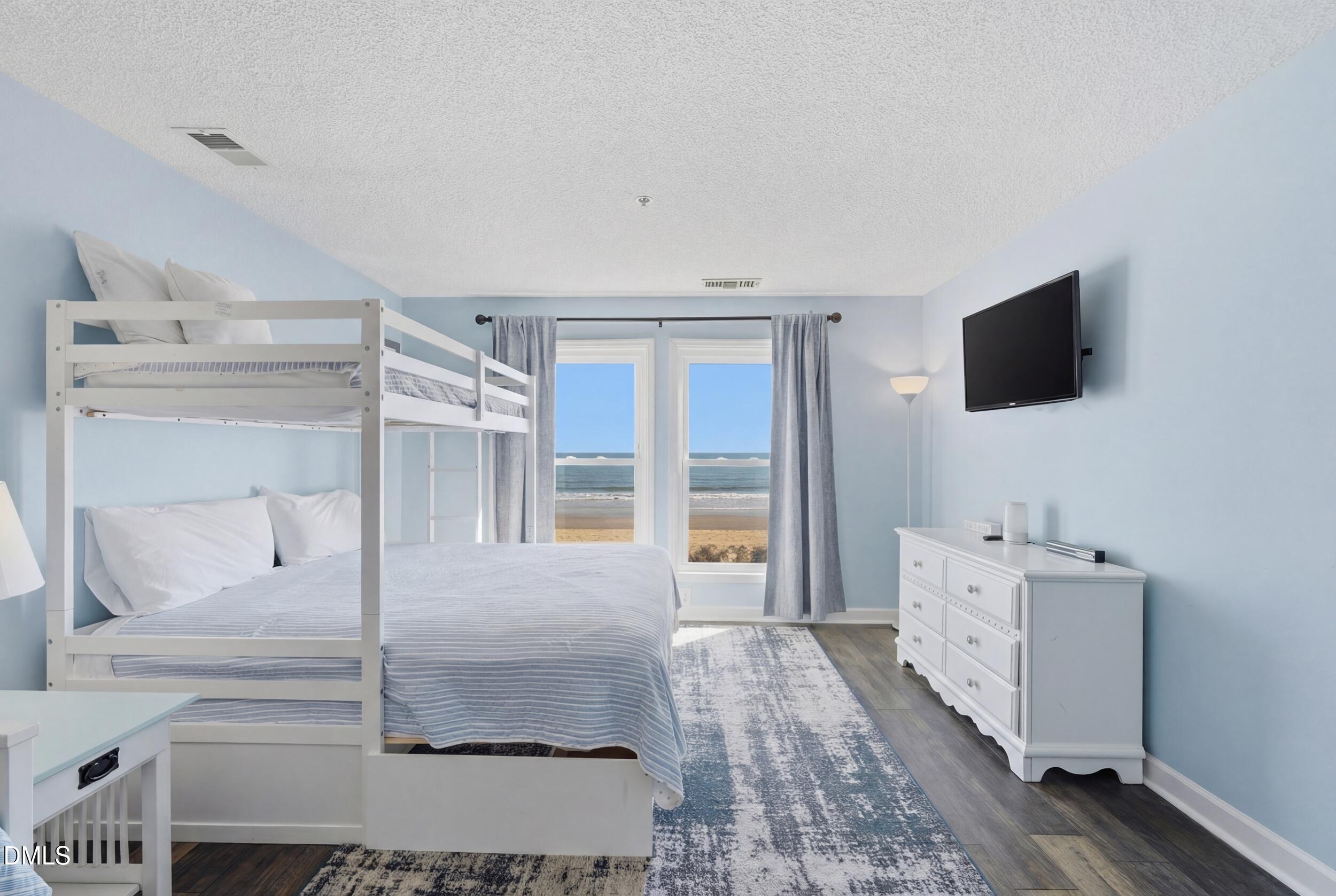 790 New River Inlet Road, Unit 114A North Topsail Beach, NC 28460 - Photo 7 of 46 a living room with furniture and a flat screen tv