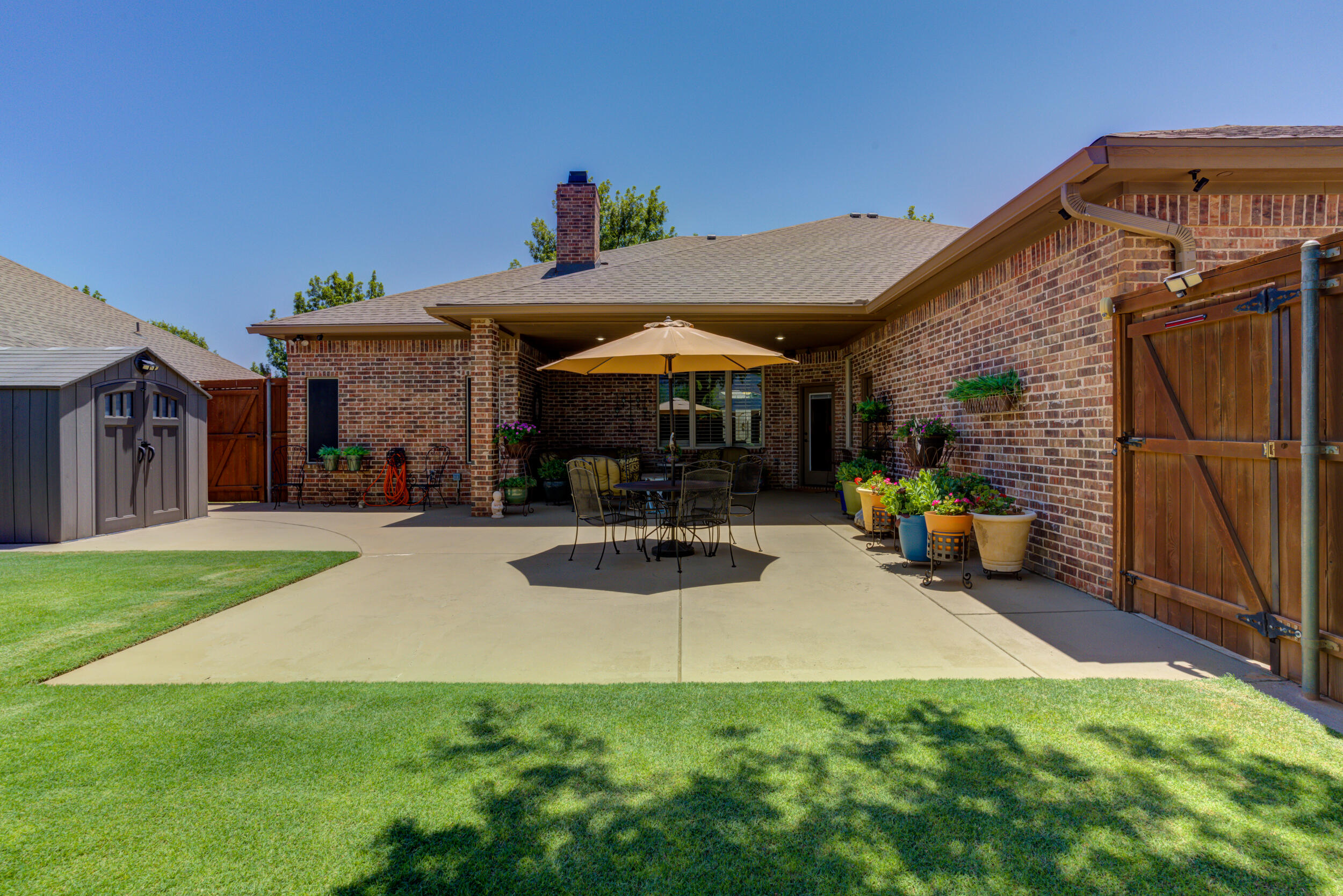6008 89th Street Lubbock, TX 79424 - Photo 56 of 61 a view of a patio with a table and chairs under an umbrella