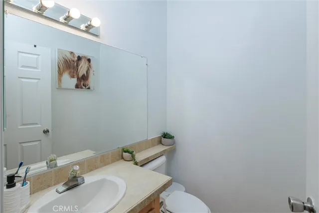 a bathroom with a sink mirror and toilet