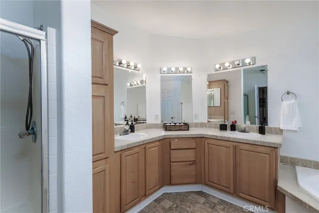 a bathroom with double vanity sinks a toilet a mirror and vanity