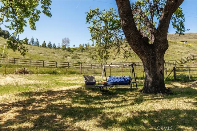 a backyard of a house with table and chairs under an umbrella
