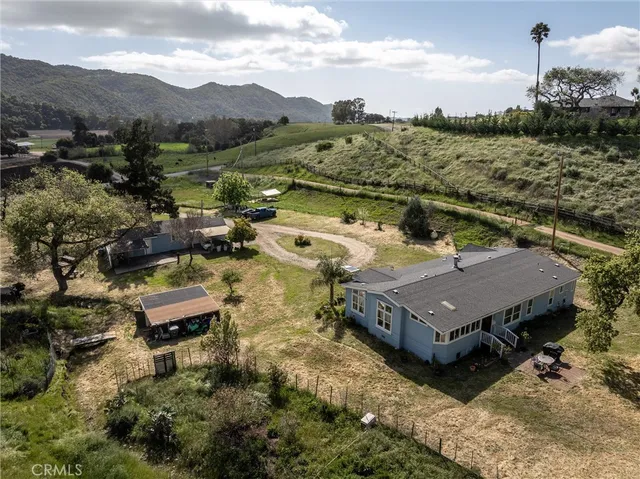 an aerial view of a house with a mountain