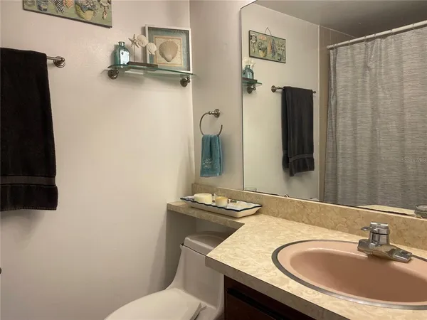 a bathroom with a sink and mirror with toilet
