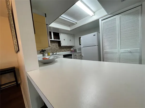 a kitchen with refrigerator and cabinets