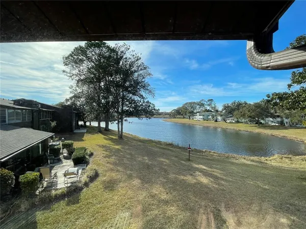 a view of a lake with couches and wooden floor