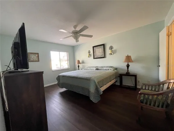 a bedroom with a bed wooden floor and a window