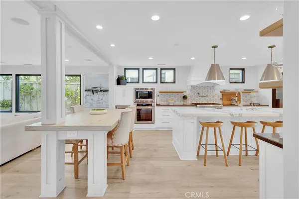 a large kitchen with kitchen island a table and chairs in it