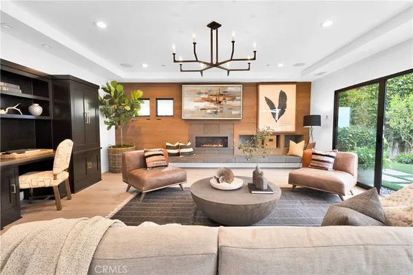 a living room with furniture a chandelier and a large window