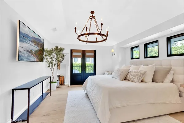a bedroom with a large bed and a chandelier