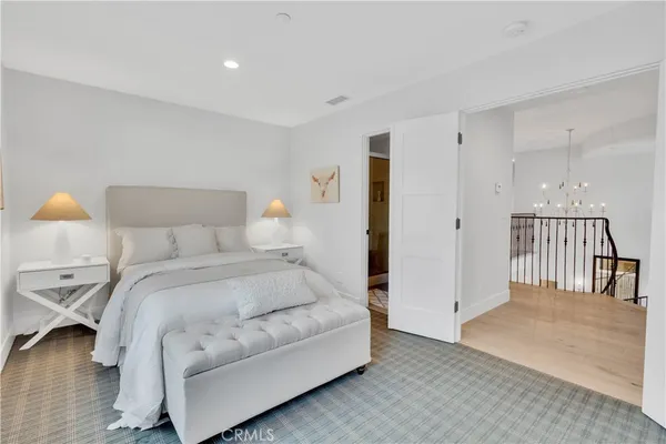 a spacious bedroom with a bed and a lamp