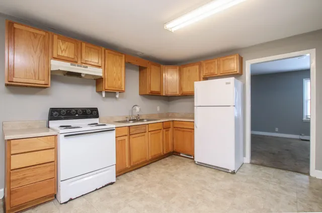 a kitchen with a refrigerator sink stove and cabinets