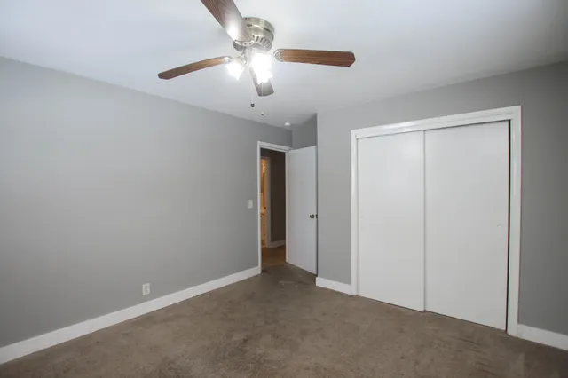 an empty room with chandelier fan