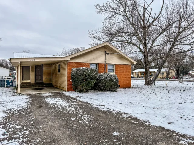 a view of a house with a yard covered in snow