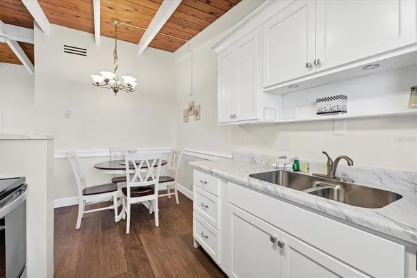 a kitchen with a sink cabinets and wooden floor