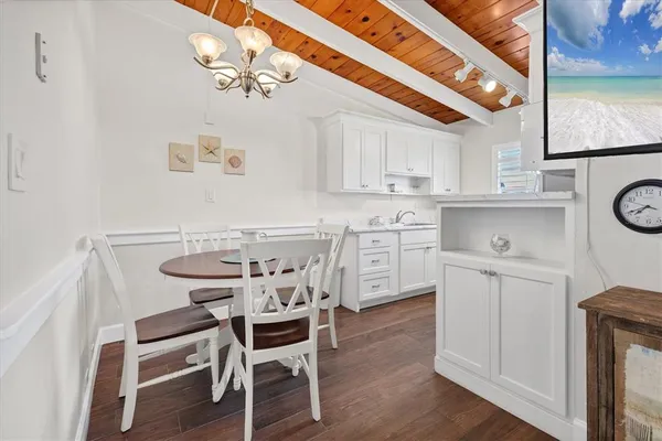 a kitchen with stainless steel appliances a white table and chairs in it