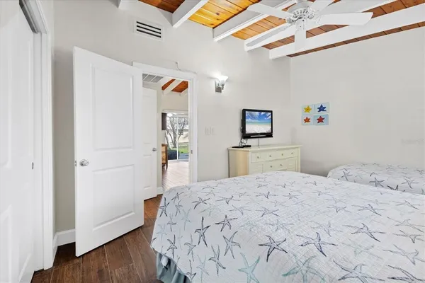 a bedroom with a bed and a wooden floor