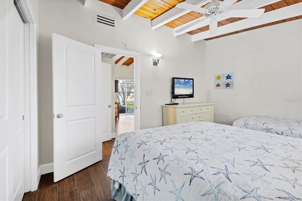 6006 Midnight Pass Road, Unit 15 Sarasota, FL 34242 - Photo 15 of 36 a bedroom with a bed and a wooden floor