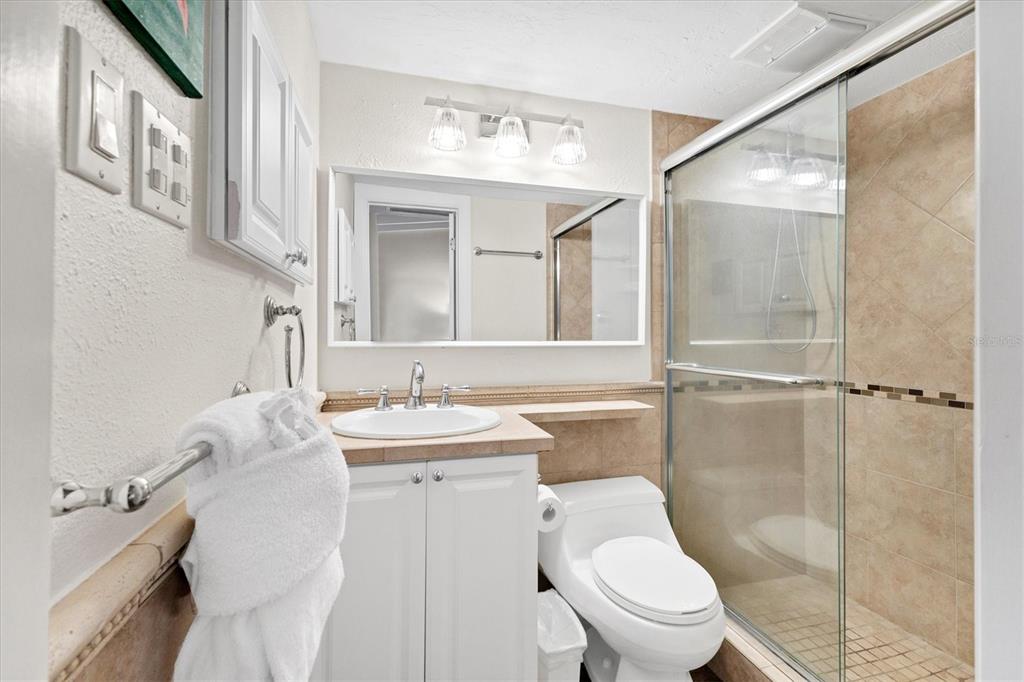 6006 Midnight Pass Road, Unit 15 Sarasota, FL 34242 - Photo 17 of 36 a bathroom with a toilet sink and mirror