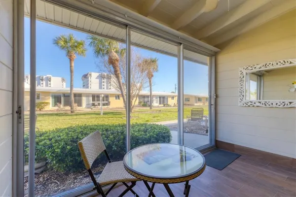 a view of a porch with furniture and a yard