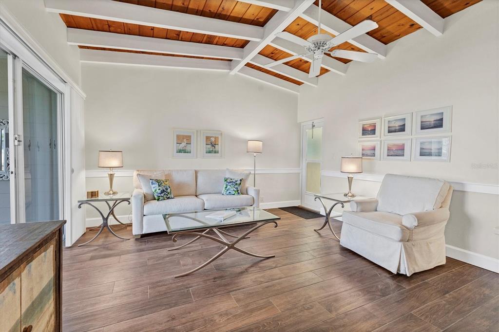 6006 Midnight Pass Road, Unit 15 Sarasota, FL 34242 - Photo 5 of 36 a living room with furniture and a wooden floor