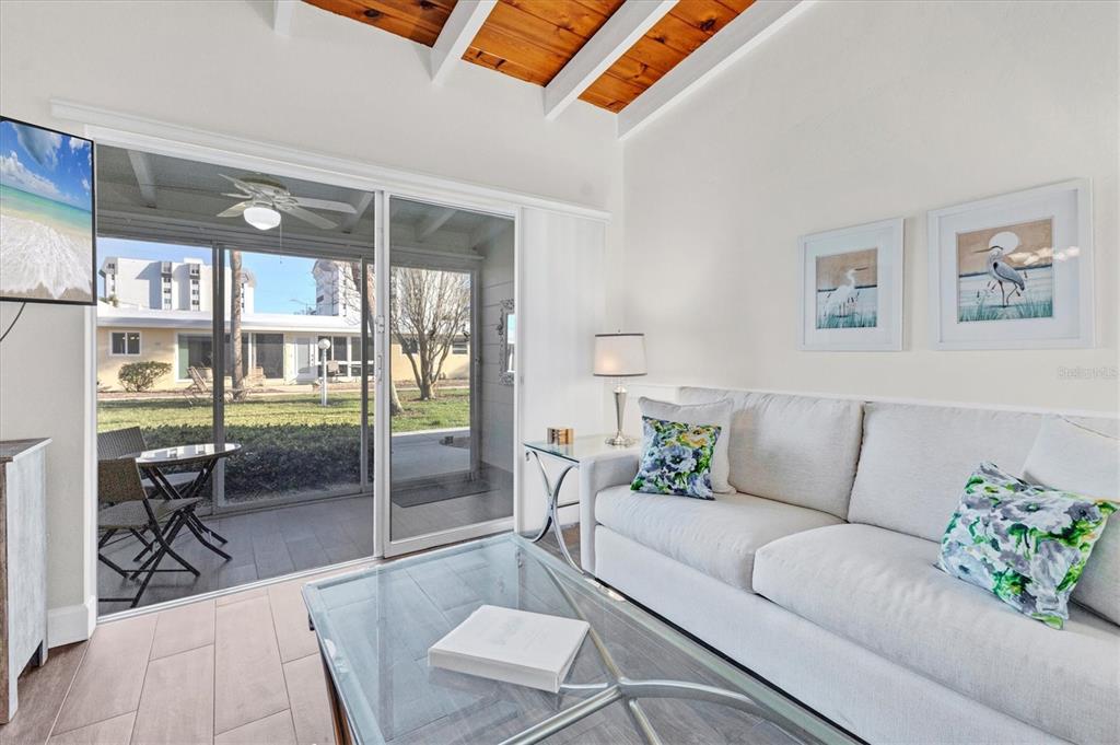 6006 Midnight Pass Road, Unit 15 Sarasota, FL 34242 - Photo 6 of 36 a living room with furniture and a floor to ceiling window