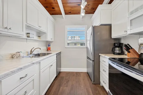a kitchen with granite countertop a sink stove and refrigerator