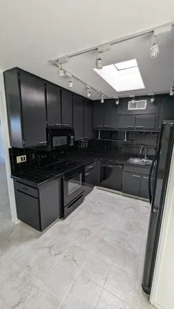 a kitchen with granite countertop a stove and a refrigerator
