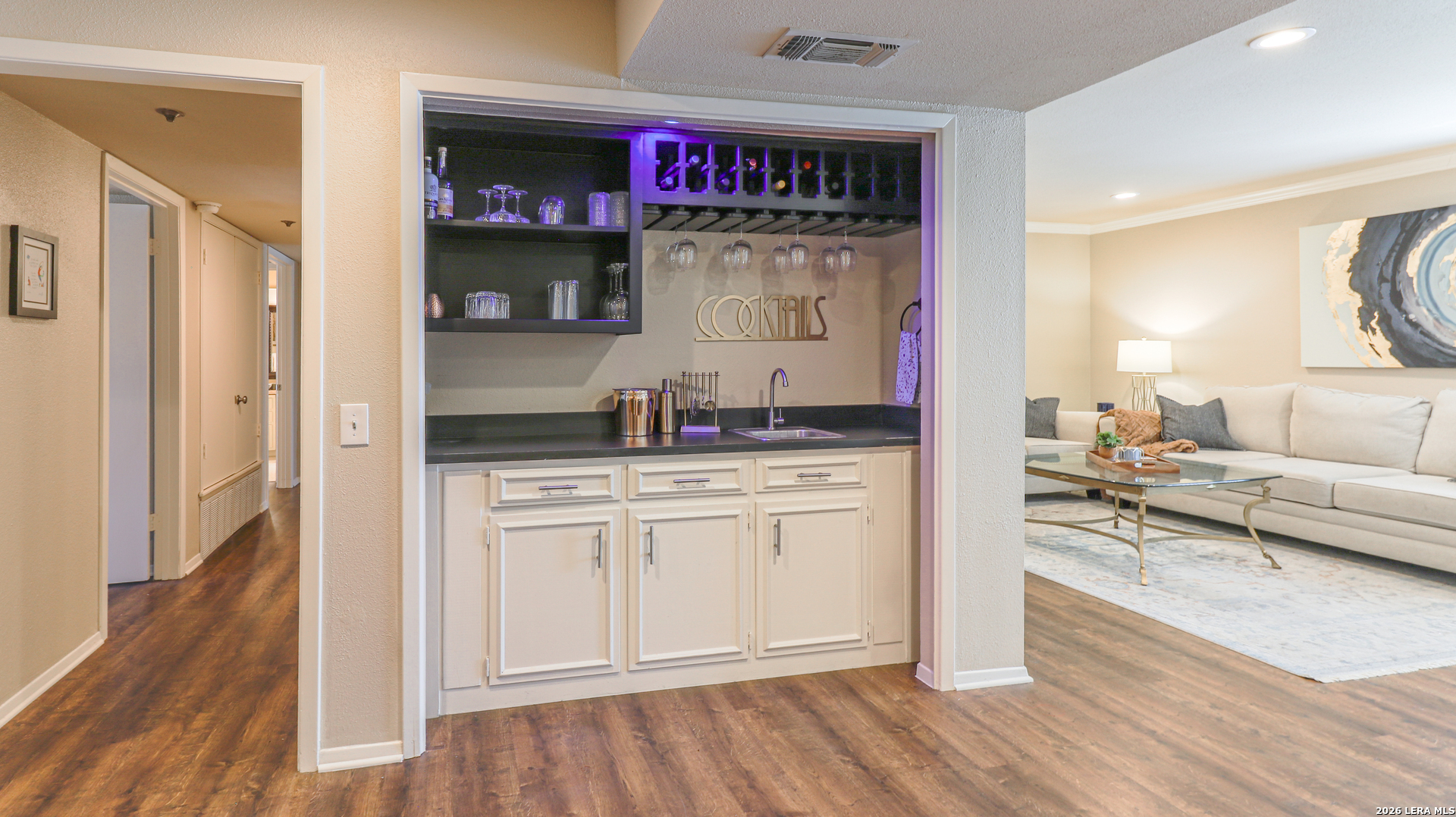 7500 Callaghan Road, Unit 236 San Antonio, TX 78229 - Photo 6 of 19 a kitchen view with microwave a stove and white cabinets with wooden floor